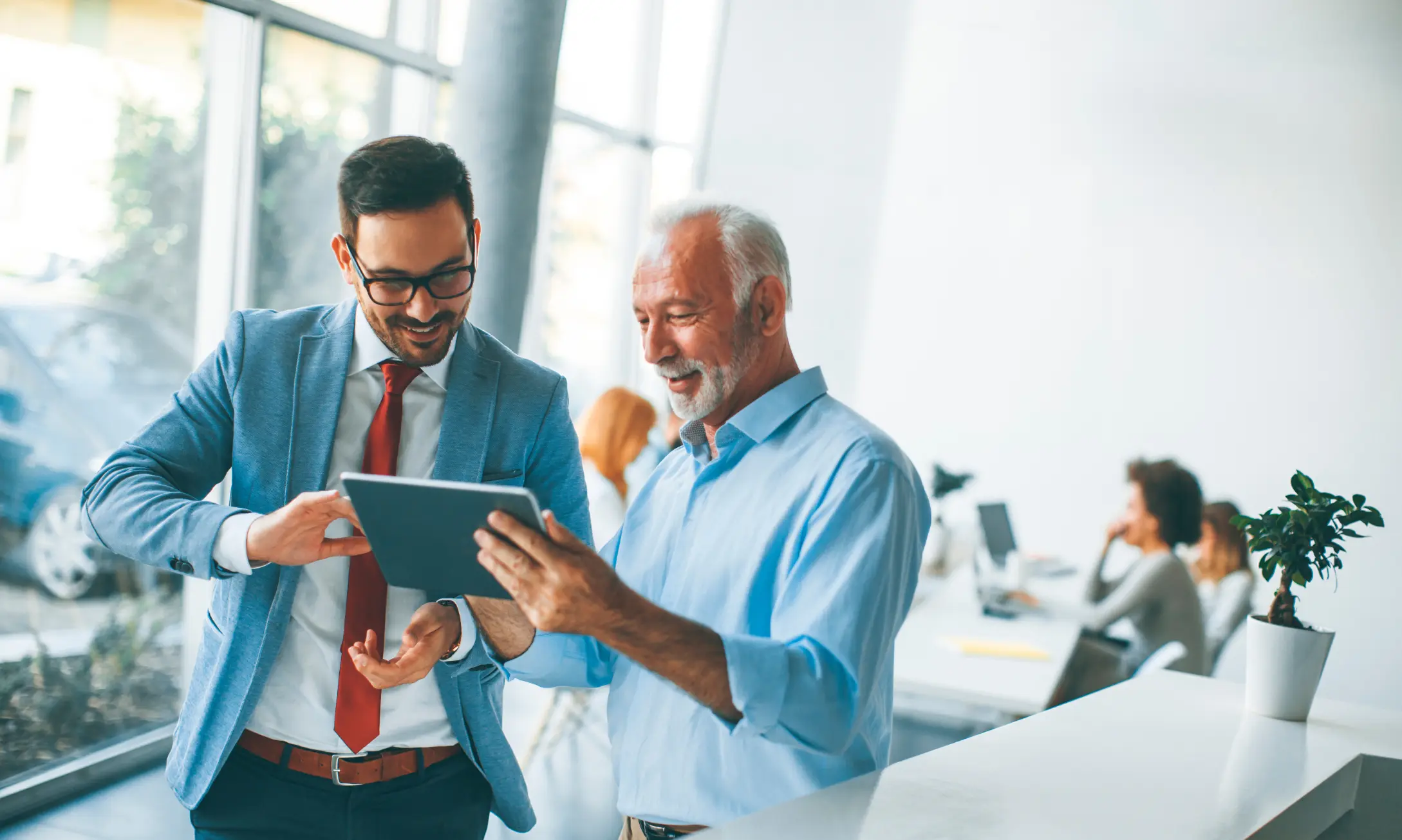 Conseiller et dirigeant échangeant autour d’une tablette pour améliorer l’organisation de travail